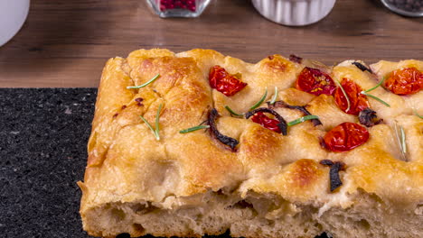 Traditional-Italian-Focaccia-with-pepperoni,-cherry-tomatoes,-black-olives,-rosemary-ando-onion---homemade-flat-bread-focaccia