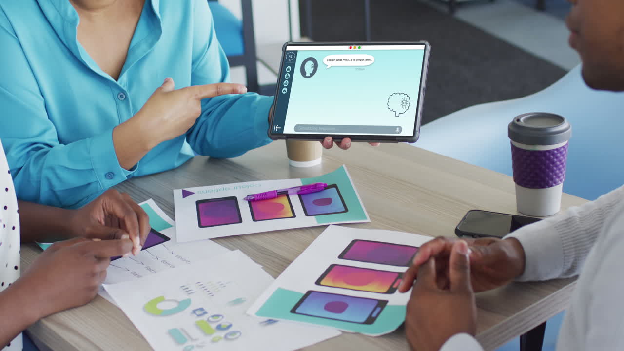 Diverse business people in office using tablet with data processing on screen