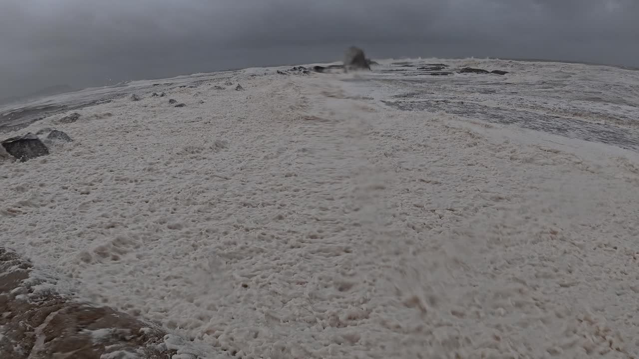 Strong Waves And Wind Blowing The Foam onto The Shore Of Currumbin Beach During Cyclone Alfred. - pan shot