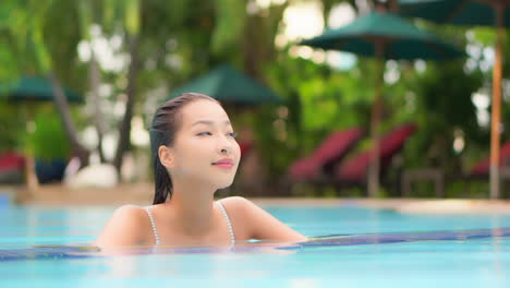 Close-up-of-an-attractive-young-woman-in-a-resort-swimming-pool