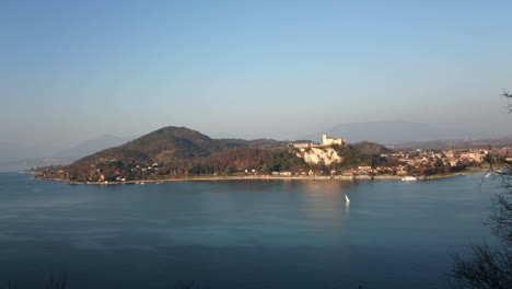 Aerial-view-of-lake-Maggiore-from-Rocca-of-Arona-with-castle-of-Angera-and-sailboat-sailing-in-the-distance-4k