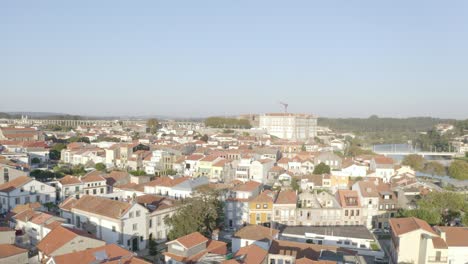 Drone-view-descending-over-an-antique-villa-in-Portugal,-revealing-a-cluster-of-houses-during-sunset