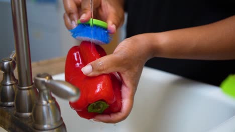 lavar un pimiento dulce en el fregadero de la cocina - cámara lenta