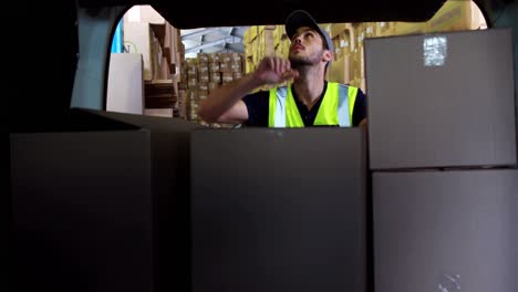 delivery driver loading his van with boxes