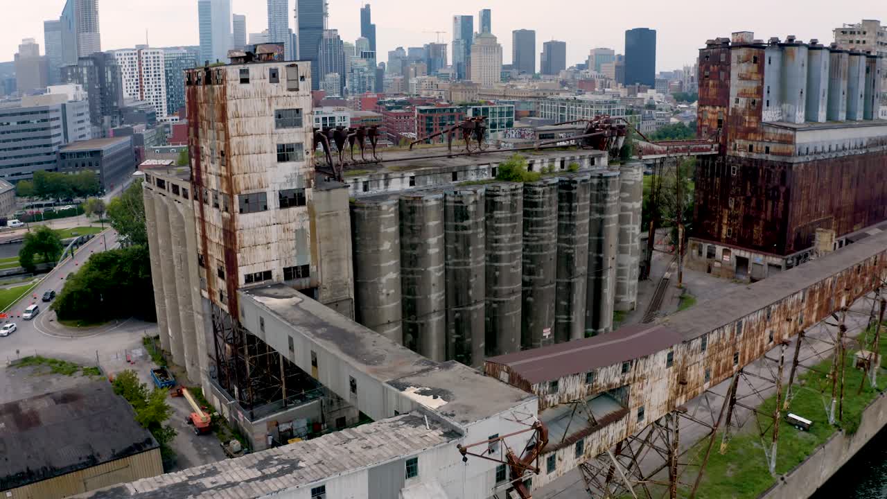 Aerial shot of an old shipping yard in Montreal, featuring rows of weathered containers and industrial cranes. Captures the raw, historical charm of the port's past operations.