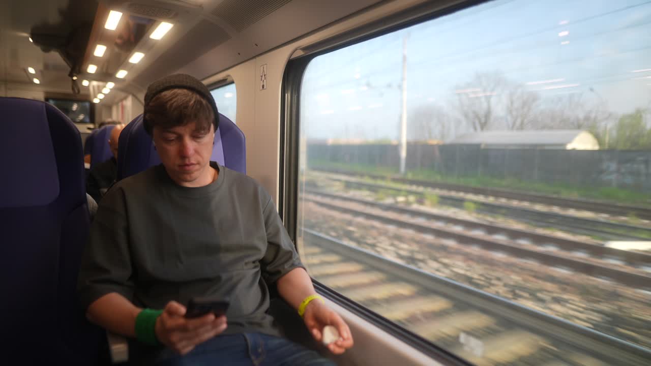 기차에서 스마트폰을 사용하는 남자