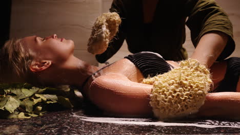 woman receiving a traditional spa body scrub