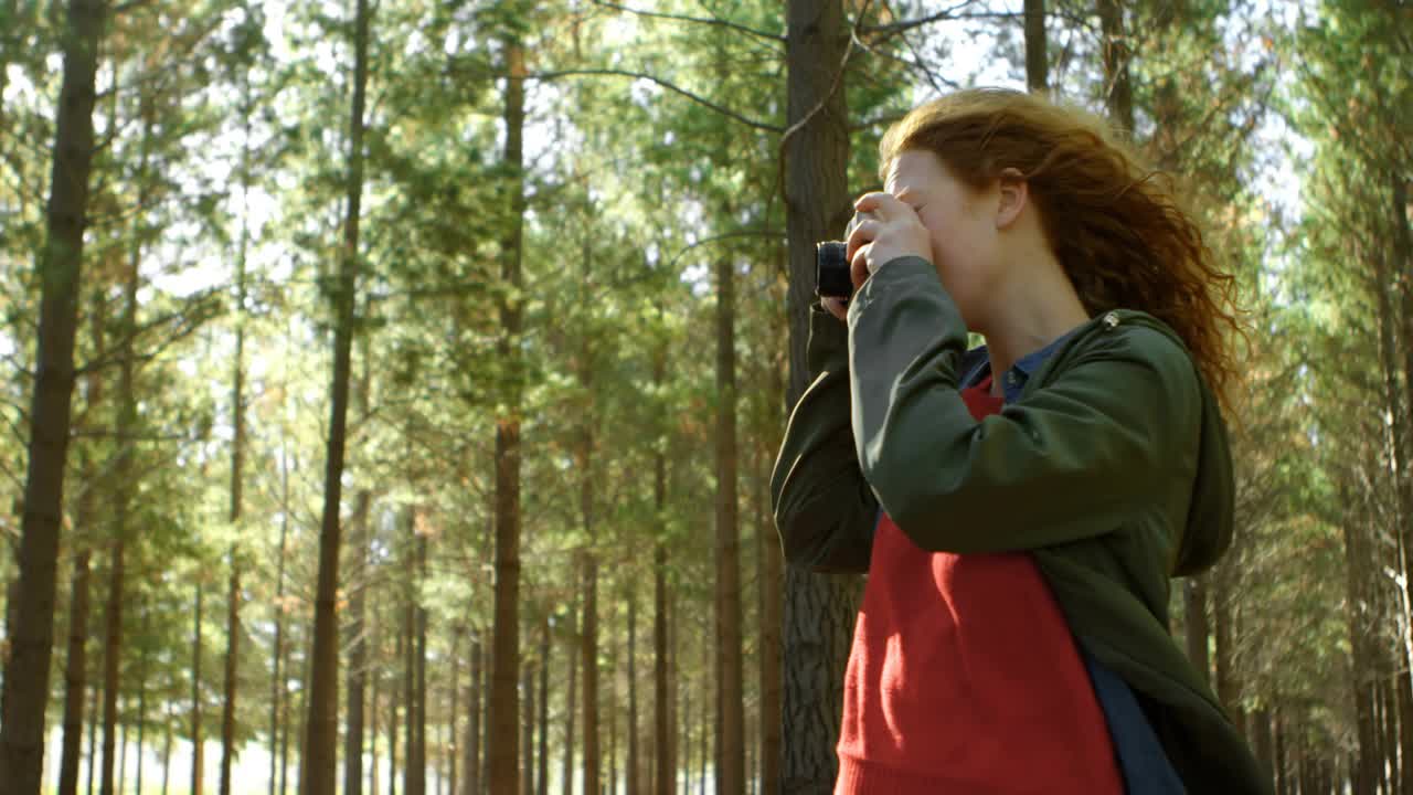 Woman raising camera for posts in pines sparking social tags flooding then fading while lowering it