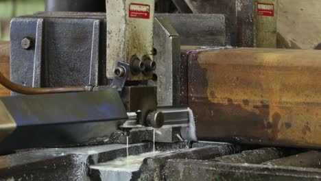 una máquina en una planta industrial de corte de metales corta una viga metálica de lapso de tiempo