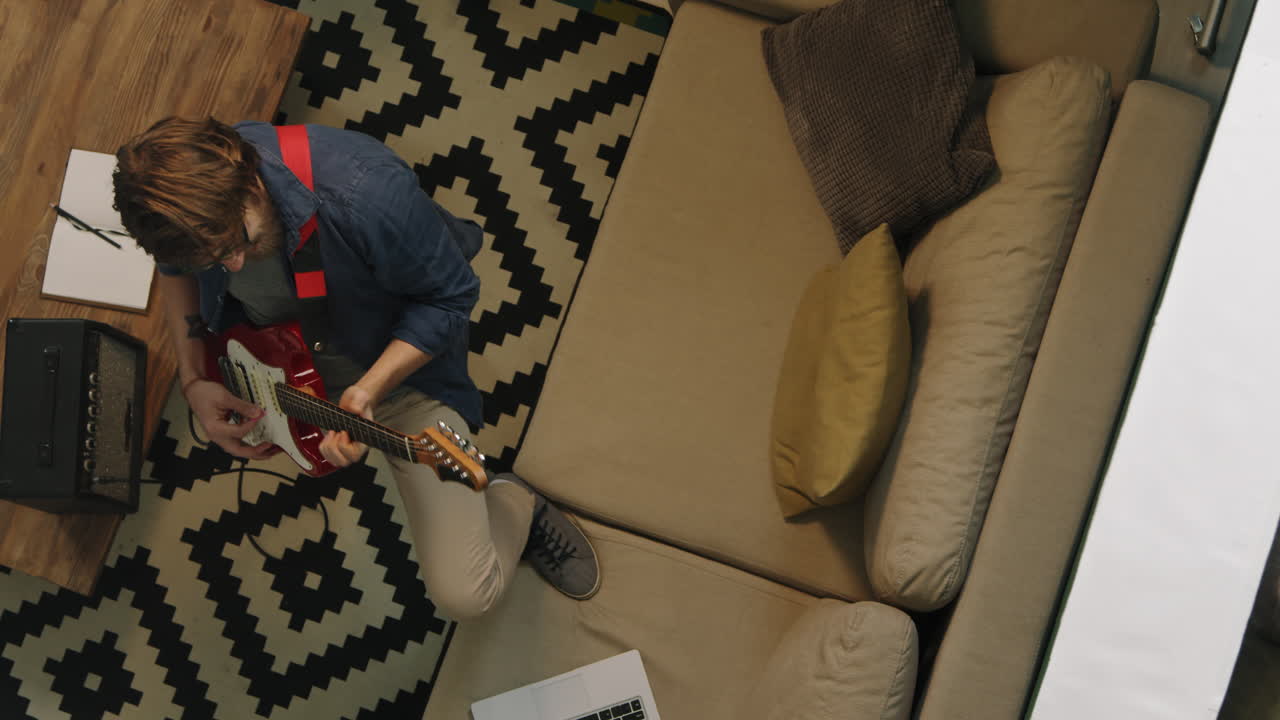 A person playing the guitar in the living room