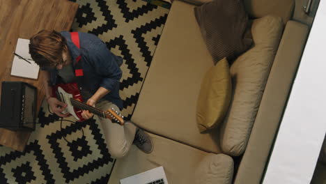 A person playing the guitar in the living room