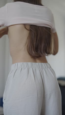 woman putting on a shirt and pants
