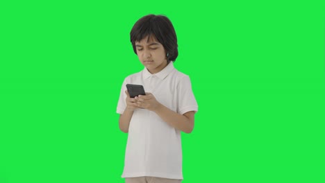 Niño-Indio-Enojado-Enviando-Mensajes-De-Texto-A-Alguien-En-La-Pantalla-Verde-Del-Teléfono