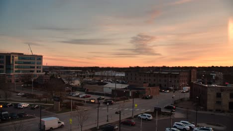 Calle-Exterior-Del-Centro-De-4k-Al-Atardecer-Con-Autos-Conduciendo-Por-Concurrida-Intersección-Hora-Dorada-Cielo-Naranja-En-Sioux-Falls-Dakota-Del-Sur