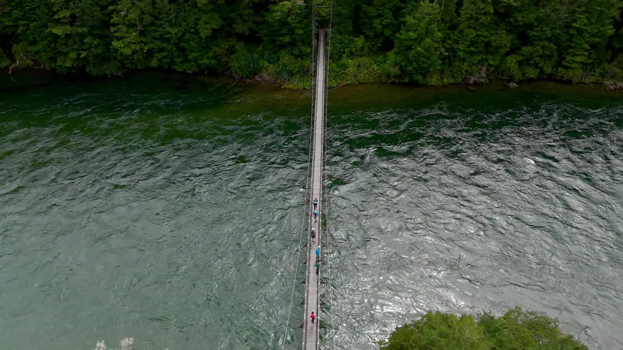 케플러 트랙, 뉴질랜드에서 강을 건너는 다리 위의 산책객 그룹 위에서 위에서 아래로 날아가는 항공기