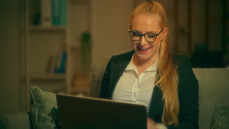 mujer feliz disfruta trabajando en la computadora portátil por la noche