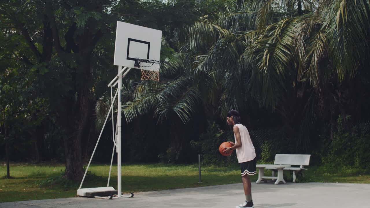 Streetball Player Throwing Ball in Ring on Outdoor Playground