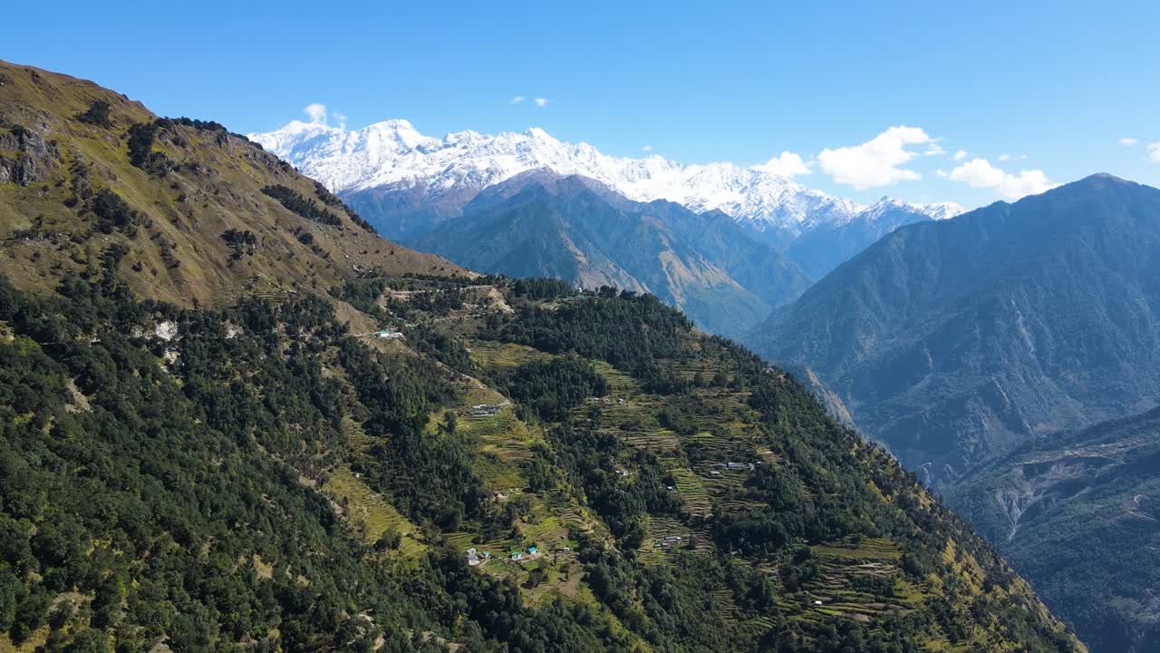 una toma aérea de un dron que ofrece una impresionante vista de un pueblo escondido en las exuberantes cadenas verdes del himalaya.