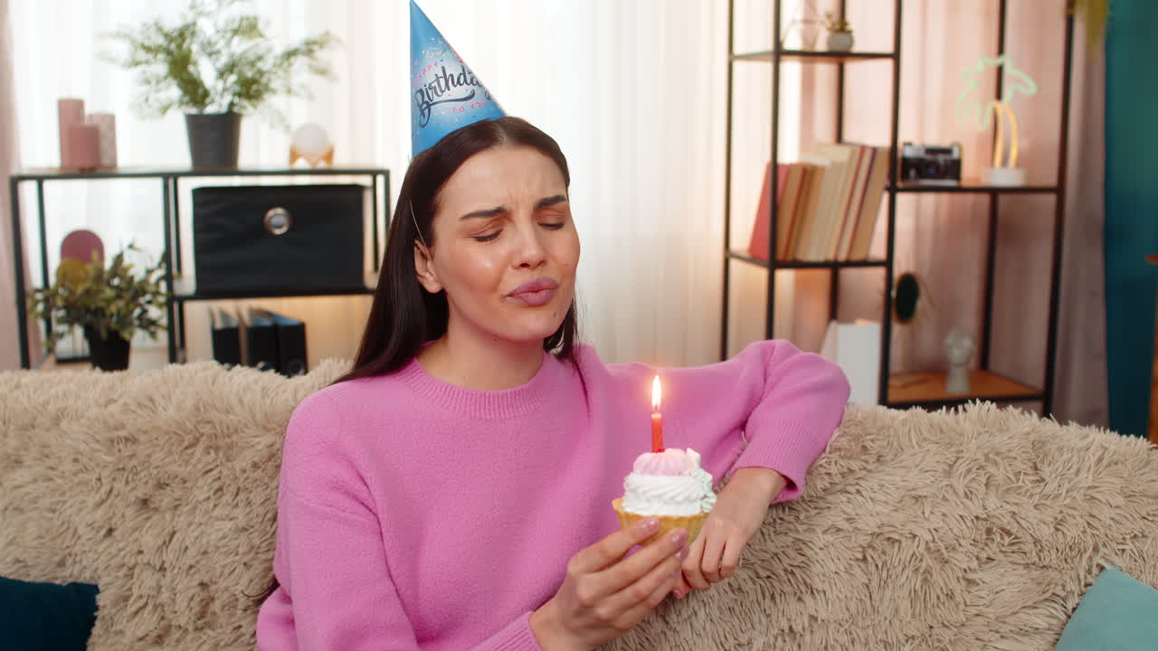 Sad lonely woman celebrating birthday alone holding cake with lit candles nobody attending party