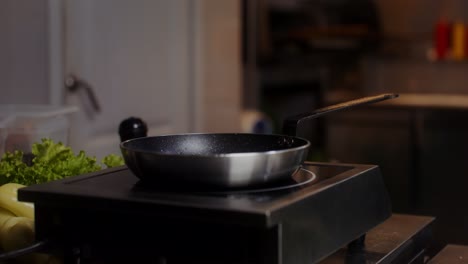 empty frying pan on hot plate in kitchen