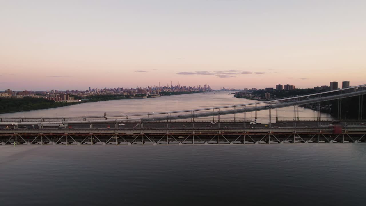 New York City skyline at dusk, traffic on the George Washington Bridge in foreground