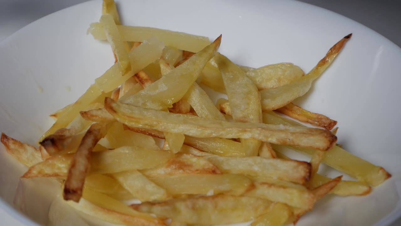 Crispy salted fries served in a white bowl, golden-brown and ready to enjoy