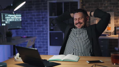 happy businessman relaxing at night in office