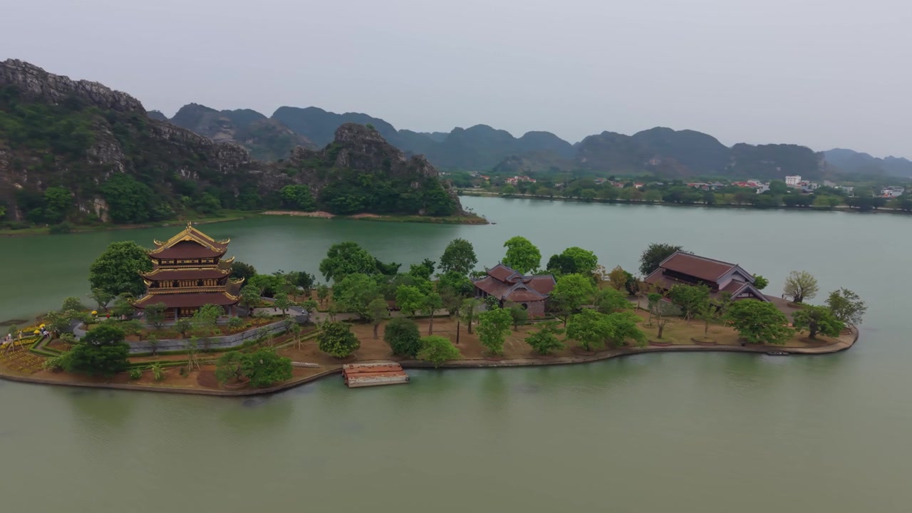 Toàn cảnh điện ảnh từ trên cao giới thiệu Chùa Vàng nằm trên một hòn đảo giữa hồ nước yên bình.