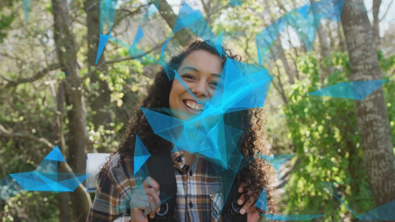 Mujer excursionista en un sendero soleado, con una malla azul flotando mostrando una sonrisa, ajustando la colchoneta de la mochila para viajar.