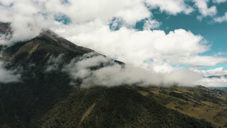 rainforest on lush valley with tungurahua volcano covered with cloudscape in ecuador