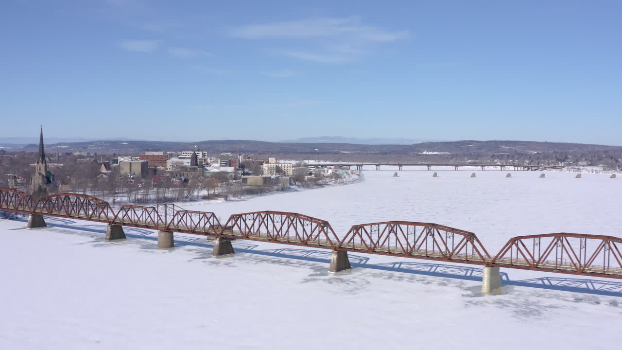 AERIAL: Moving Left In Front Of Walking Bridge In Downtown Fredericton