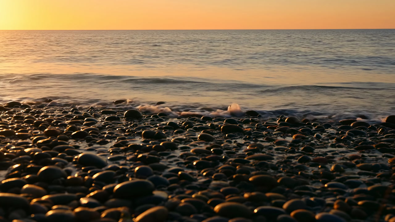 Sunset Pebble Beach With Waves, Golden Light Glinting On Wet Round Stones, Gentle Surf Rolling To Shore, Calm