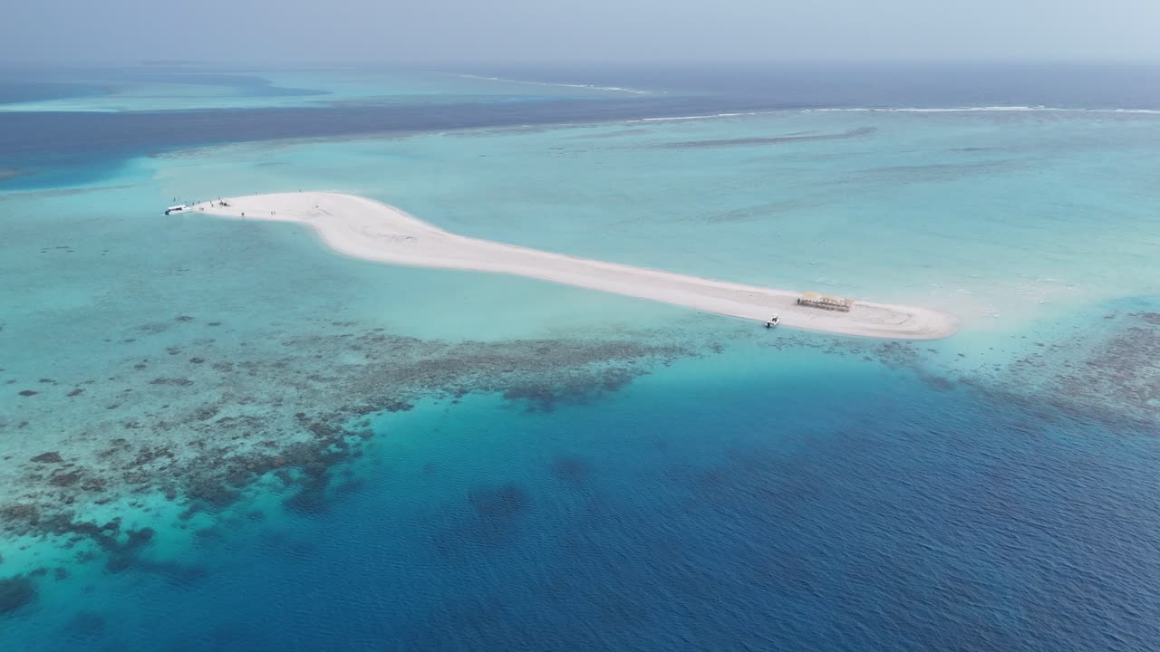 Riprese aeree con drone di un'isola con bancata di sabbia bianca in una laguna turchese, Maldive 4K