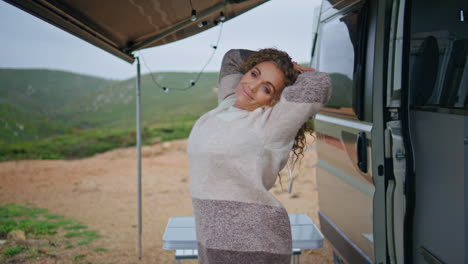 carefree tourist stretching body in campervan at autumn vacation close up.