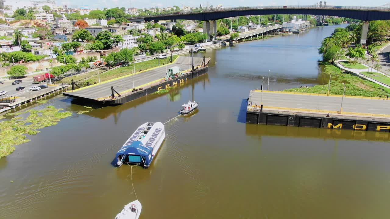 인터셉터 004, 바다-바다-강 청소 장치는 예인선에 의해 예인되어 도미니카 공화국 오자마 강에 배치됩니다.