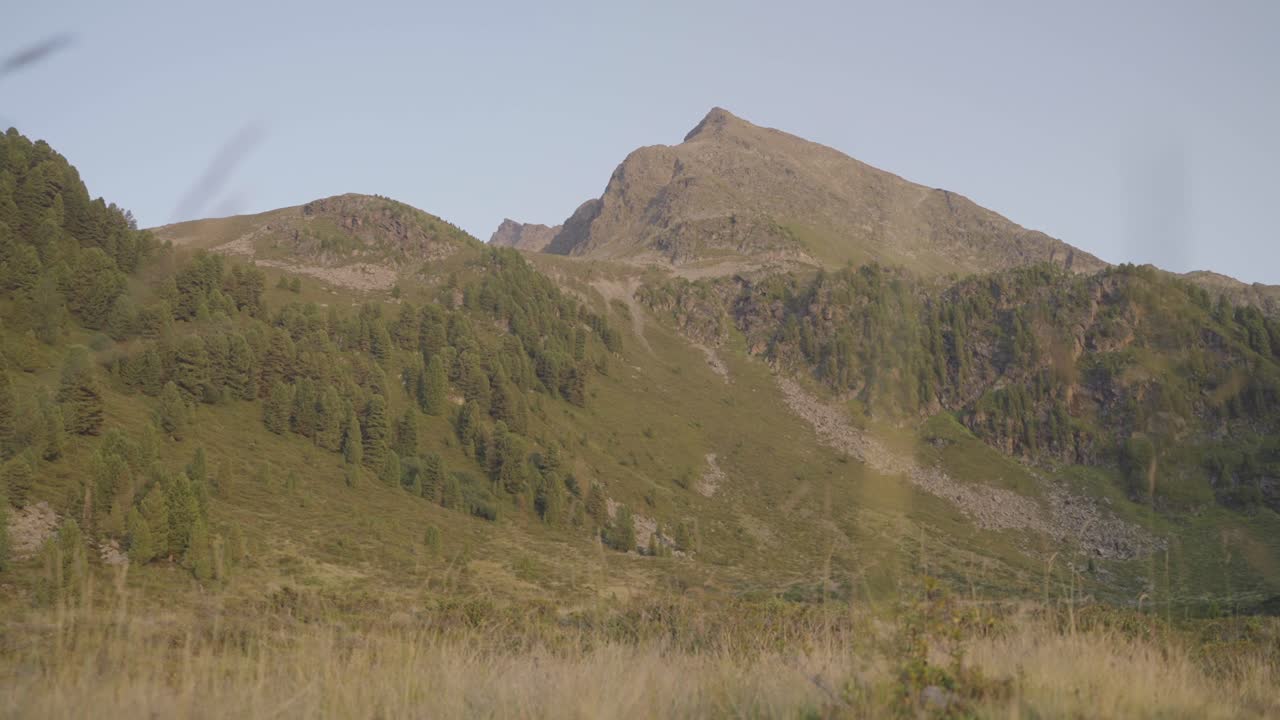 Golden hour drone shot of mountain slopes in Kühtai, bathed in warm sunset tones. Ideal for mood, travel, or nature background content