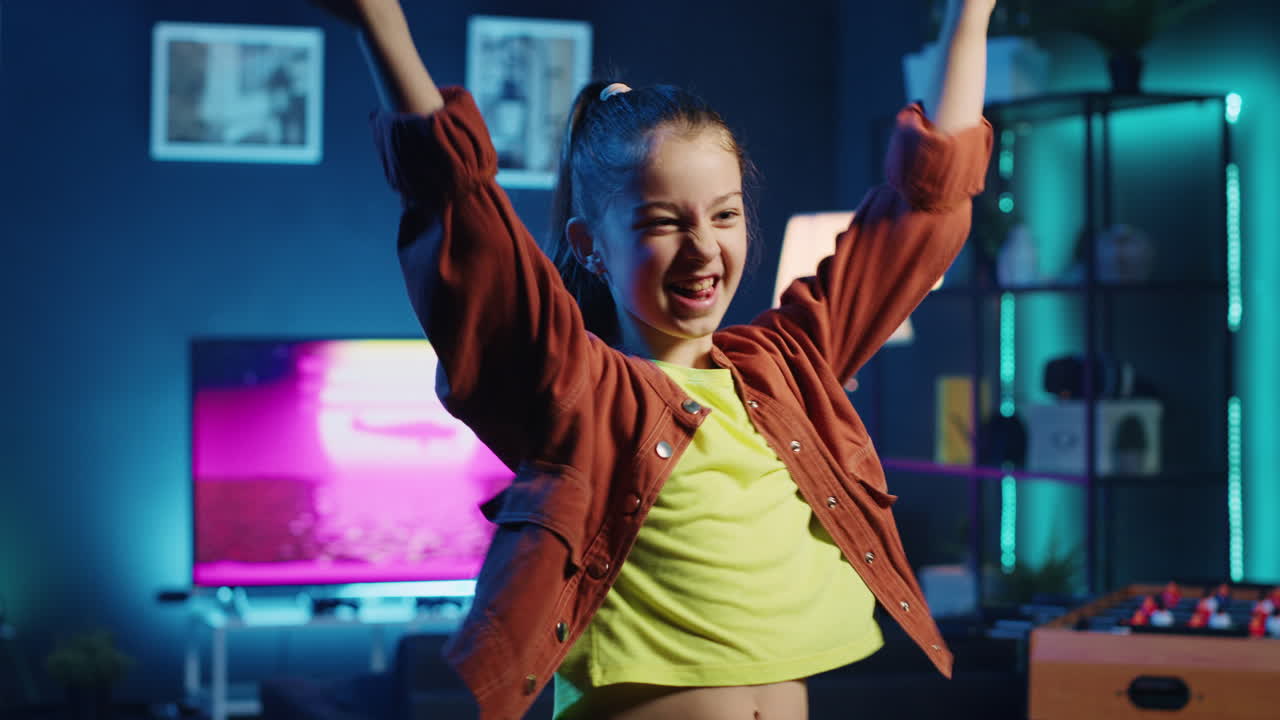 niño sonriente divirtiéndose grabando un video para los fanáticos en línea en un estudio casero con poca luz