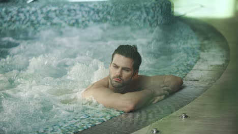 Handsome-man-resting-in-jacuzzi-spa.-Sexy-man-relaxing-in-whirlpool-bath