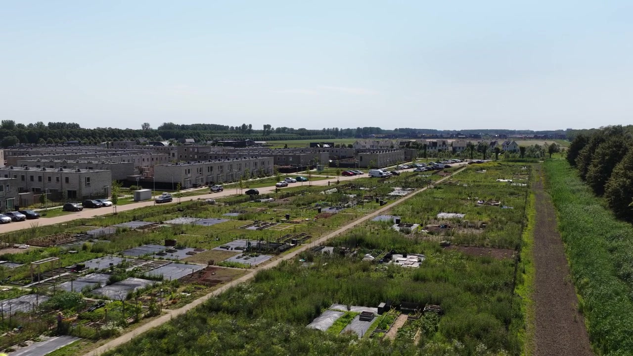 Aerial view of urban farming in a modern sustainable residential area, showing community food production, green living and climate adaptive neighborhood design.