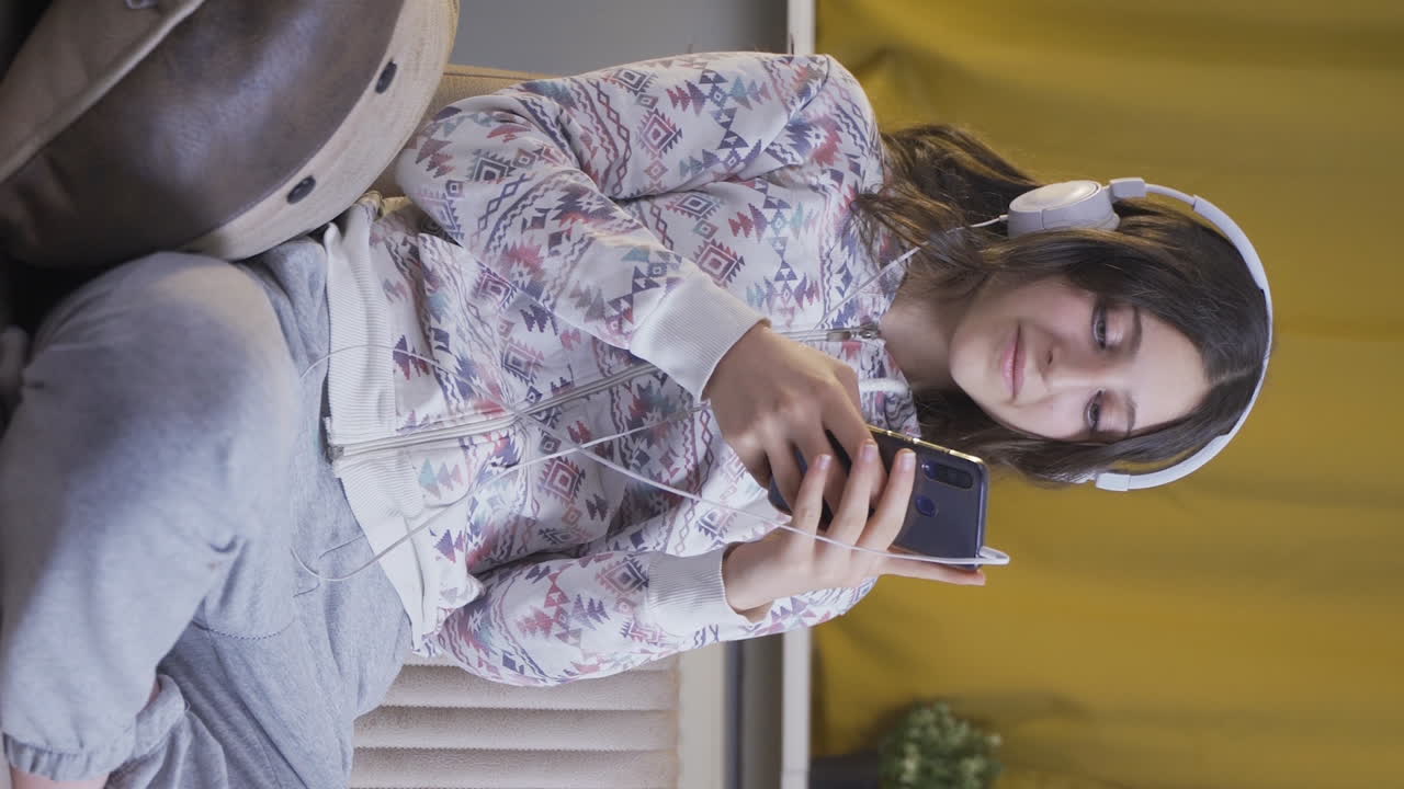 el video vertical de la joven enamorada está enviando mensajes de texto por teléfono.