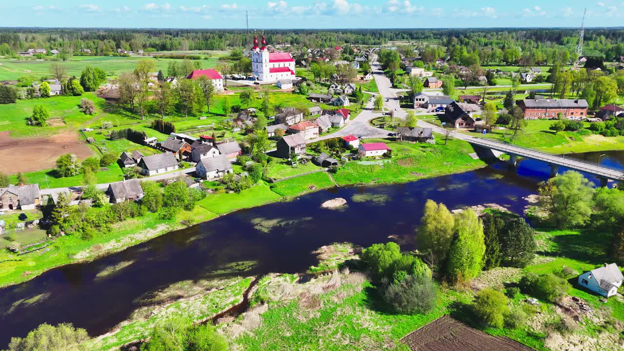 A picturesque lithuanian village with green fields and a river, aerial view