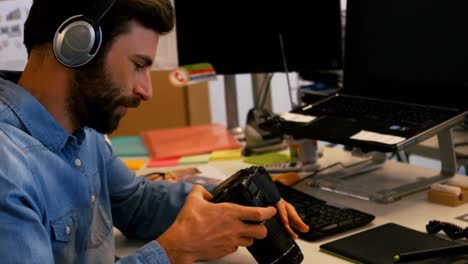 graphic designer looking at digital camera in creative office