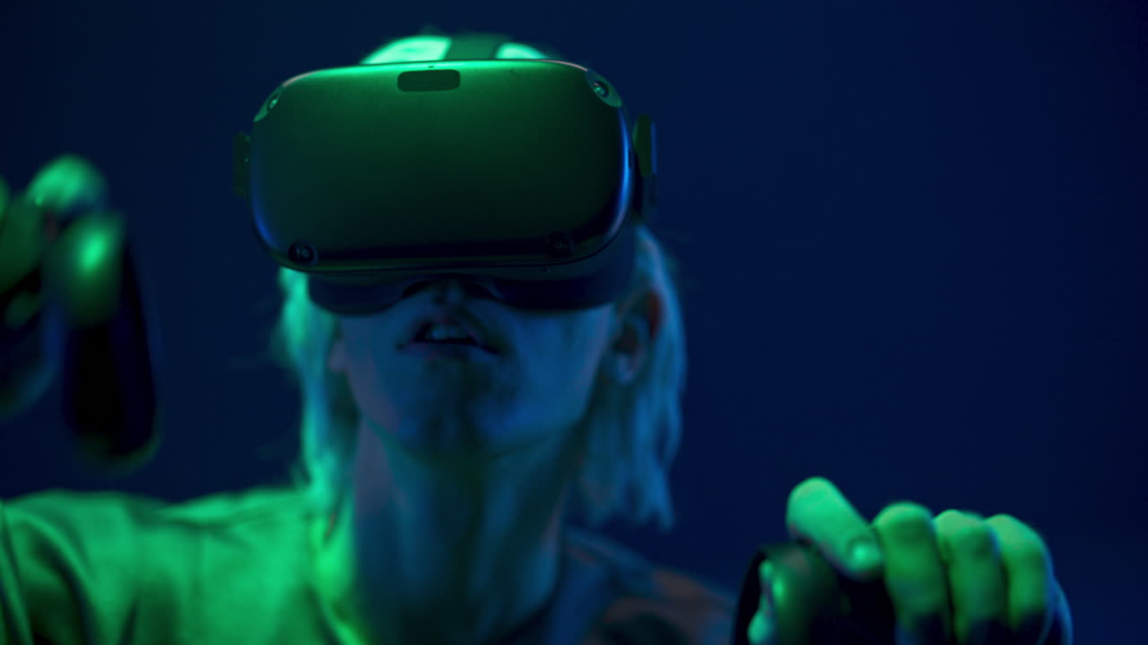 Amazed man playing videogame with remote controllers closeup. Future concept