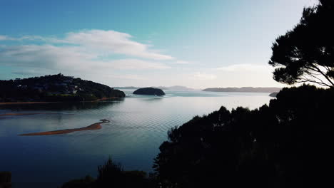 silhouette of bay of islands during serene bright sunset in new zealand