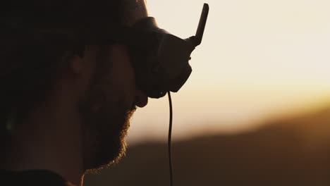 hombre con barba y cabello largo se pone gafas para fpv drone, primer plano