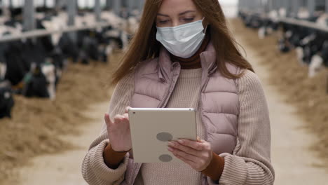 female dairy farm worker using tablet and posing