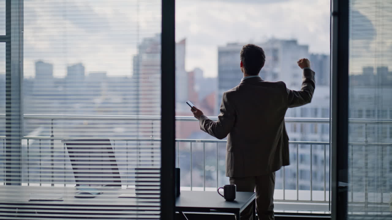 Confident boss reading smartphone notification rejoicing achievement at office