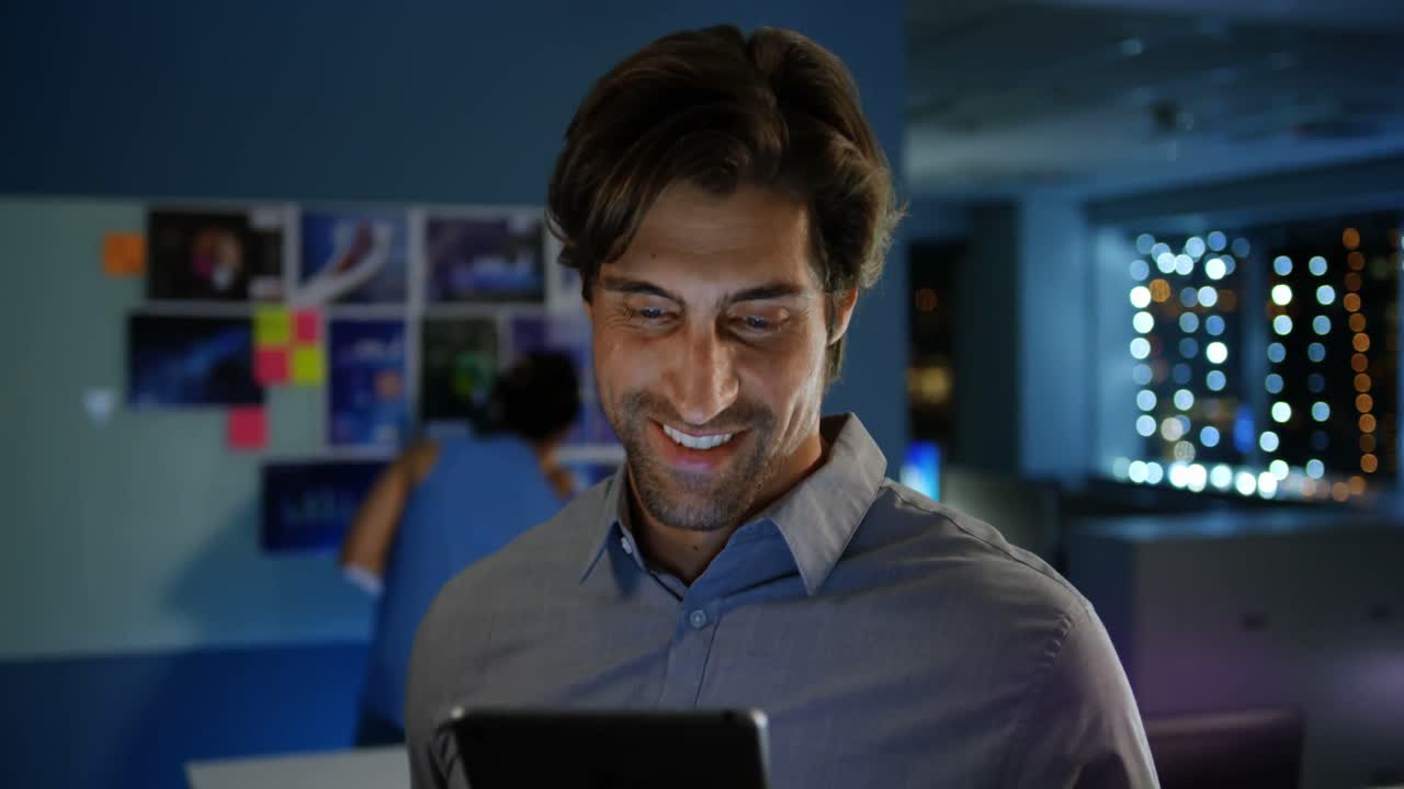 vista frontal de un joven ejecutivo caucásico feliz trabajando en una tableta digital en una oficina moderna 4k