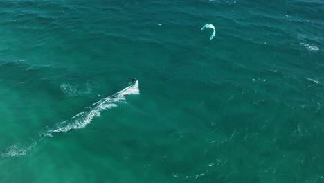 Super-slow-motion-of-kite-surfer-sailing-in-windy-turquoise-African-ocean