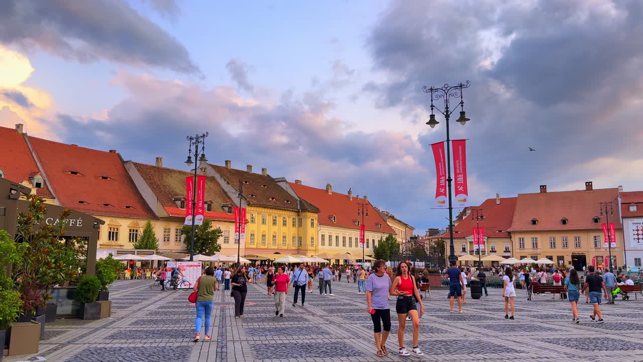 Sibiu, Romania, 1 July 2025: Crowded Square with Tourists in Sibiu. Tourists and locals walking through the central square of Sibiu, Romania, surrounded by historic buildings and cafes